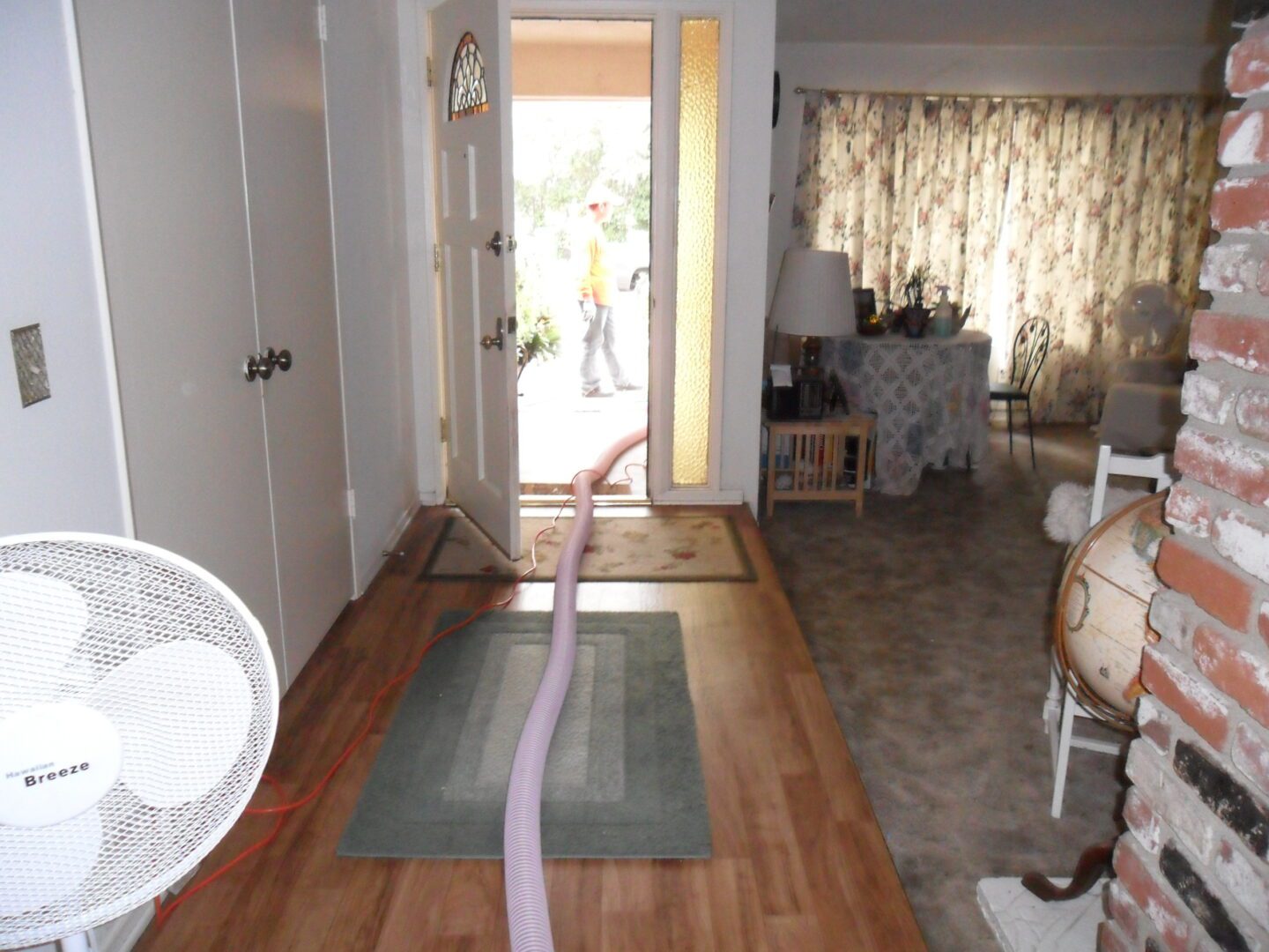 A door way with a rug and a fan in the middle of it