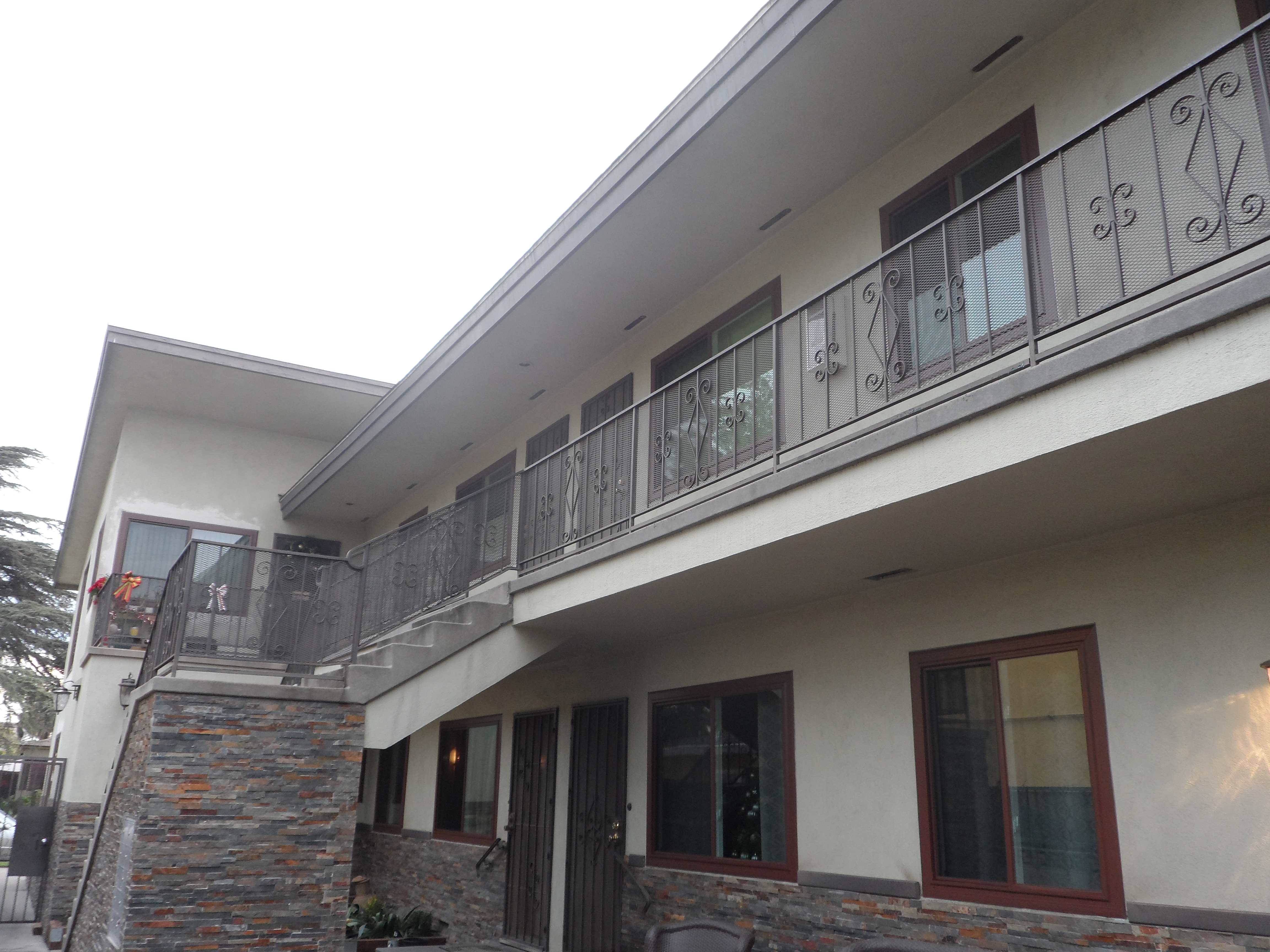 A building with a balcony and stone wall.