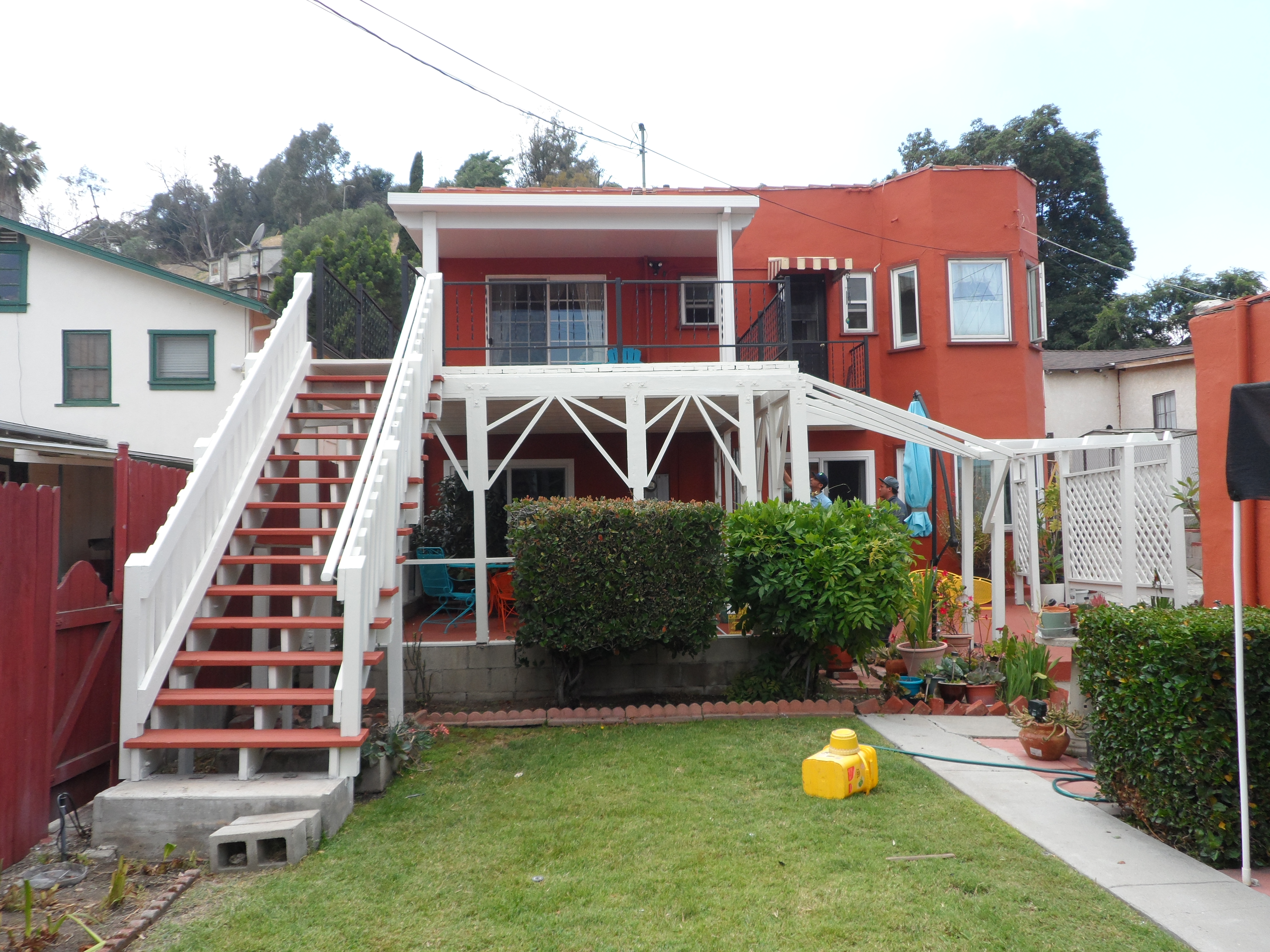 A red house with stairs going up to the top of it.