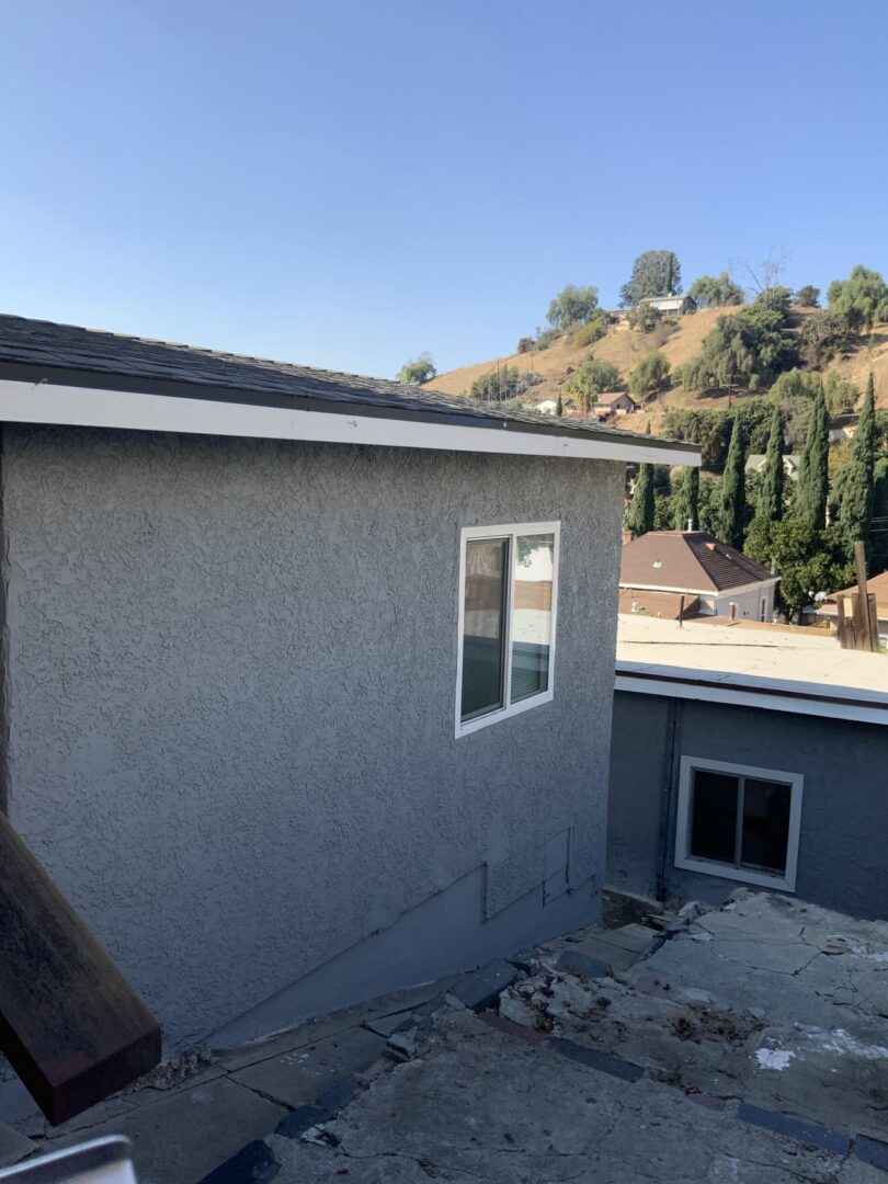 A house with a lot of windows and a roof that is not in good shape.