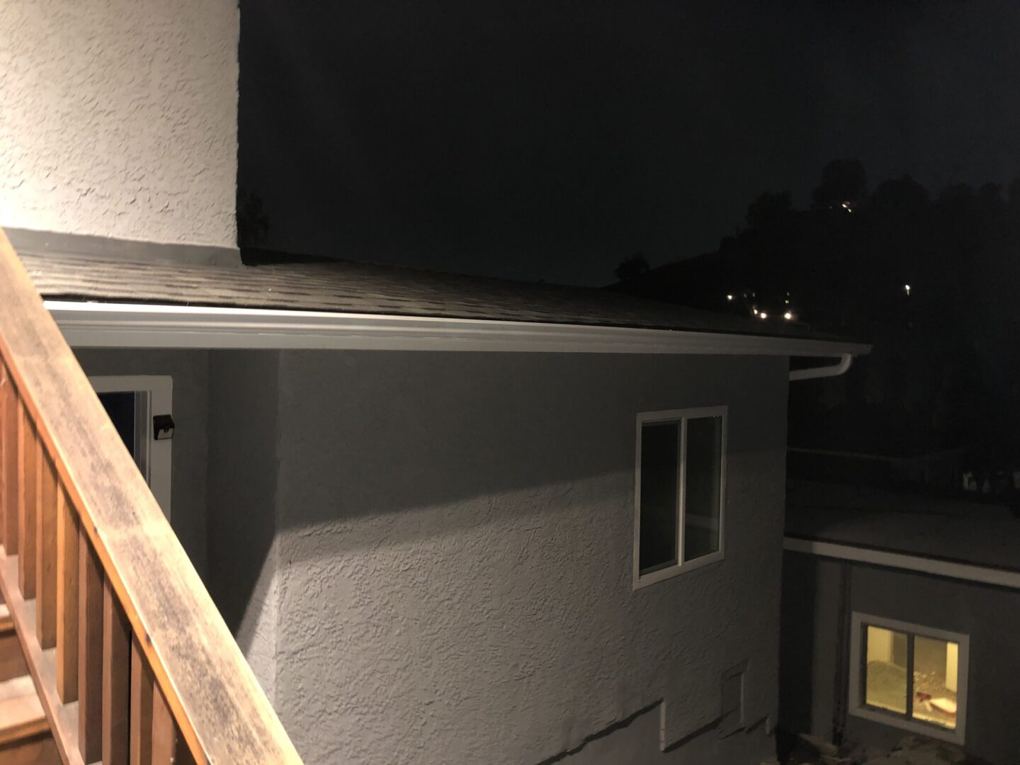 A cat is sitting on the ledge of a house.