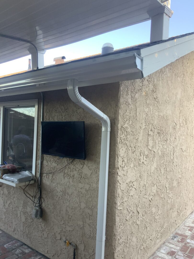 A television mounted to the side of a house.