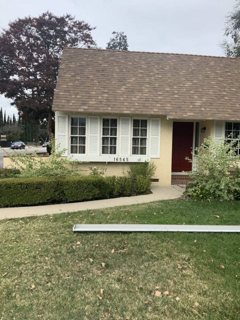 A house with a yard and bushes in front of it