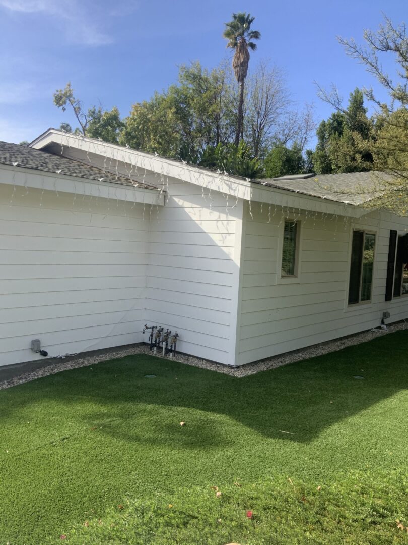 A white house with grass in the yard