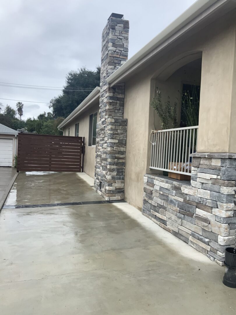 A house with a patio and stone wall.