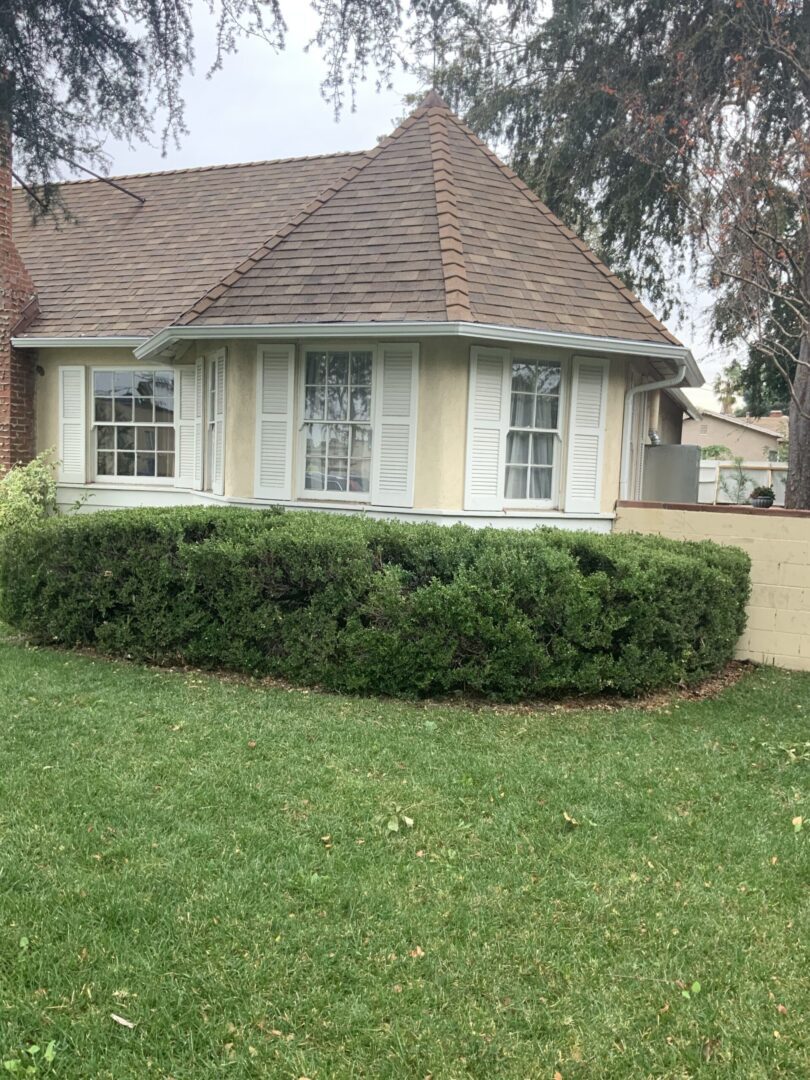 A house with bushes and grass in front of it