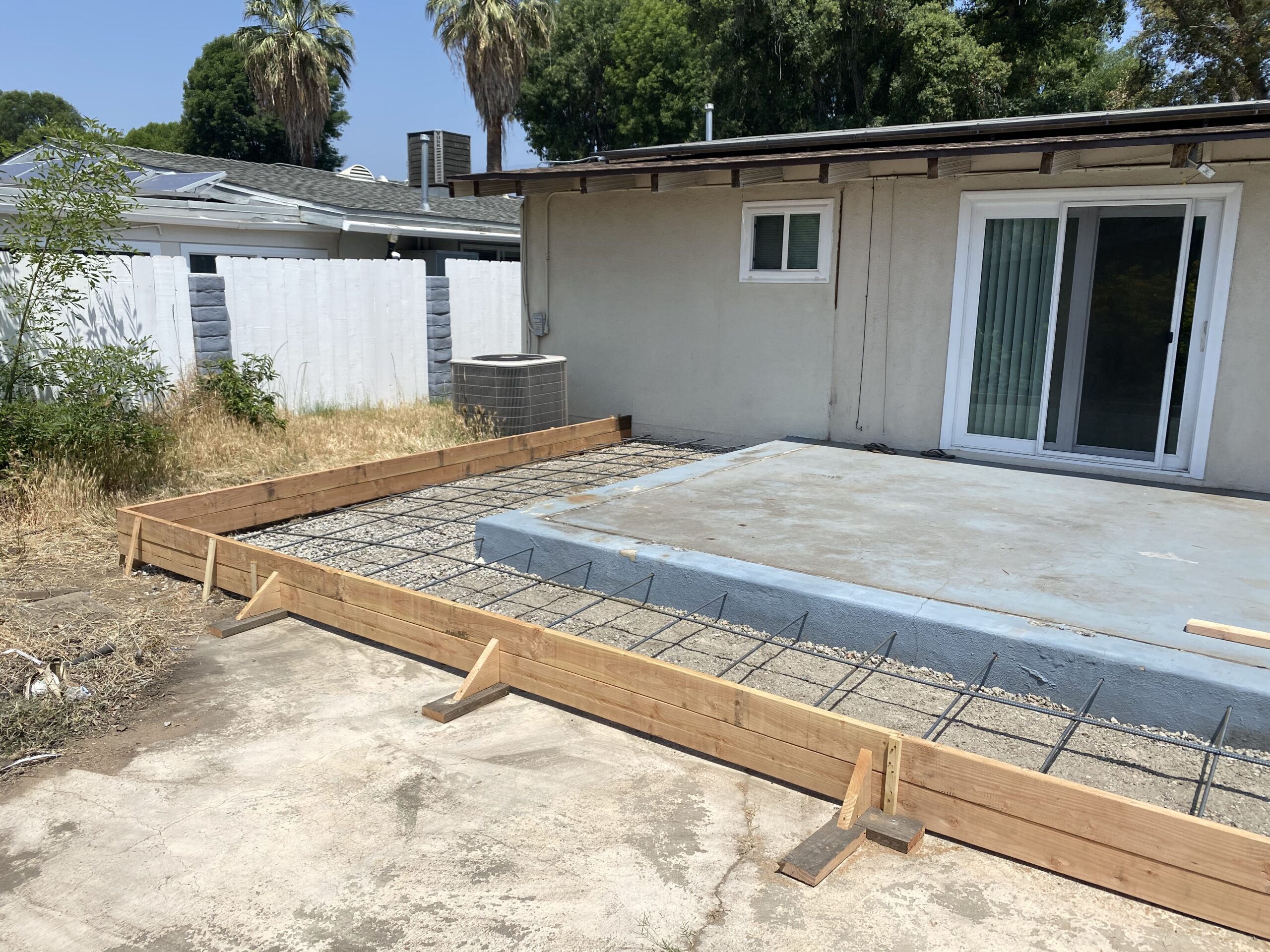 A concrete slab is being installed on the patio.