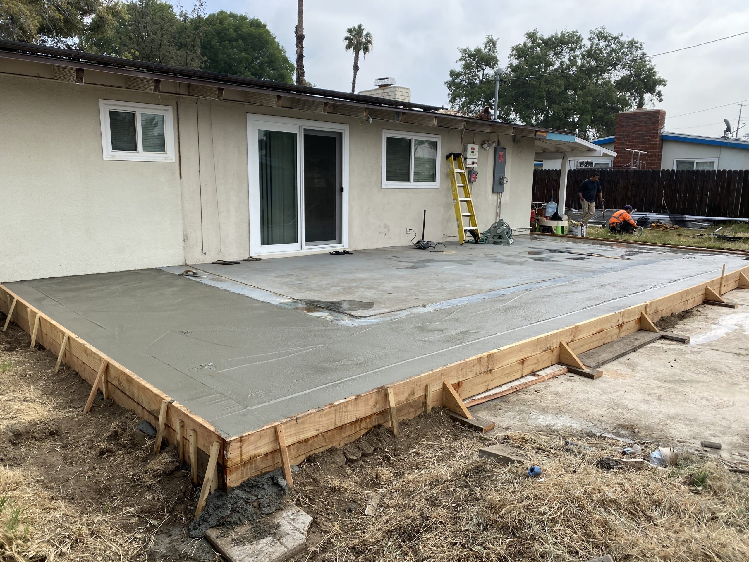 A concrete slab being poured for the front porch of a house.