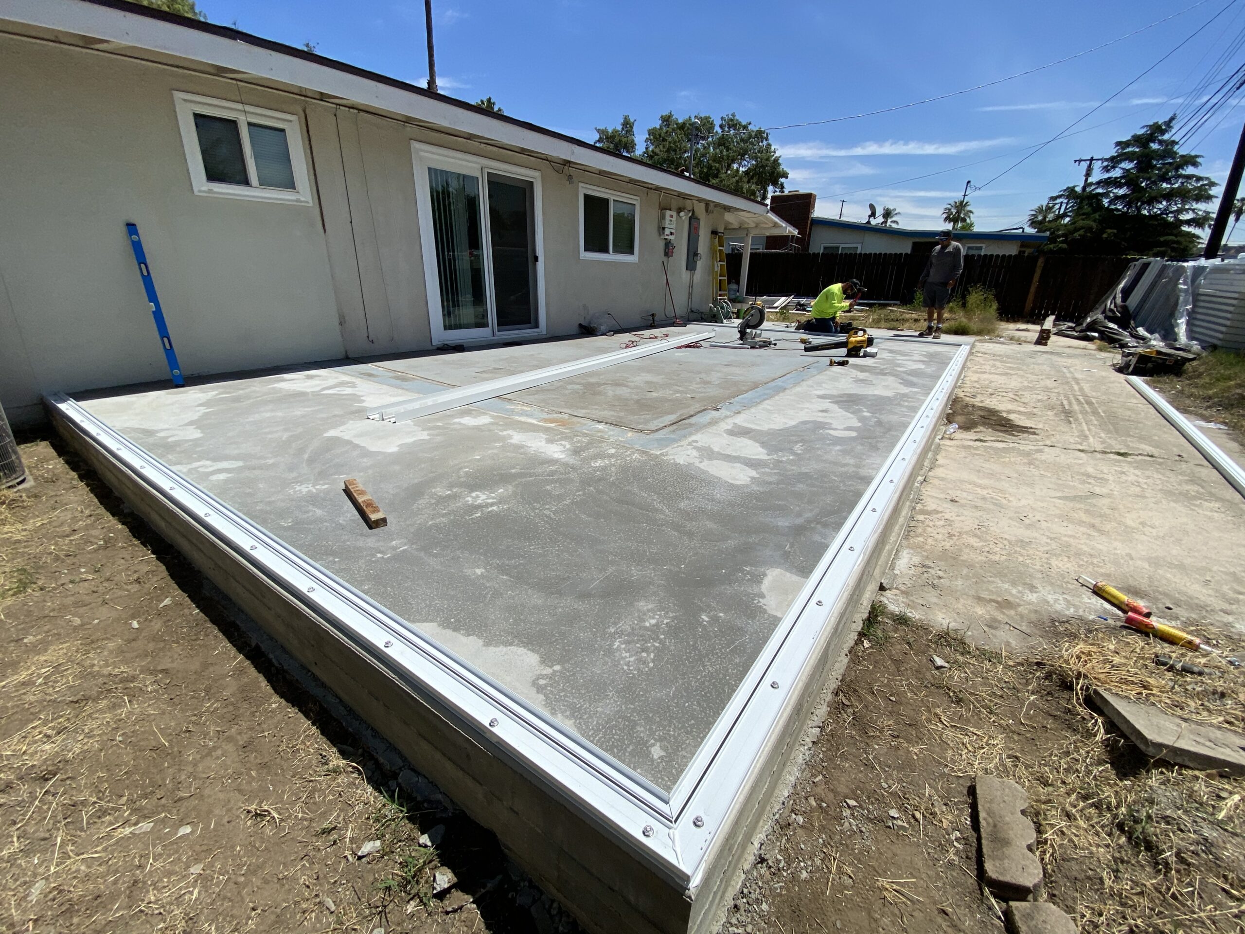 A concrete slab being installed on the side of a house.